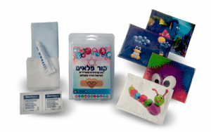 הדמיית ערכת עזרה ראשונה קרה למוסדות חינוך. בתמונה מארזי מגבונים עם איורים חמודים ומרגיעים, מארז שכתוב עליו ״קור פלאים״, פדים לחיטוי ושקיות מלח ומגבונים.